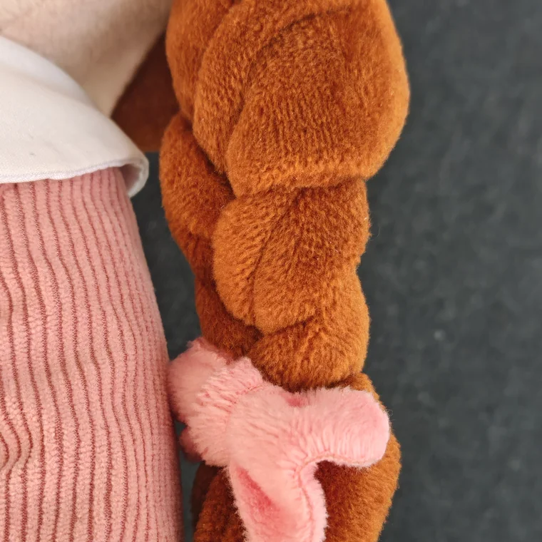 Macro photograph of Lotti's braid tied with a soft pink ribbon