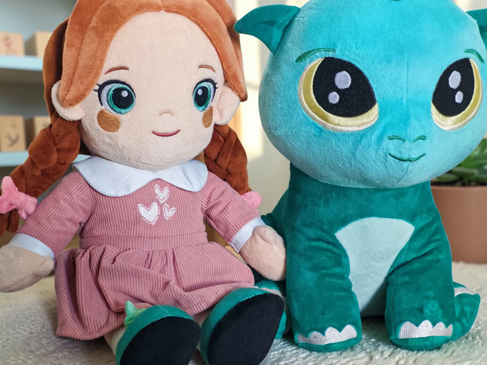 Lotti and Kobi, two of the three Playnitive plush toys, sitting side by side in a child's room