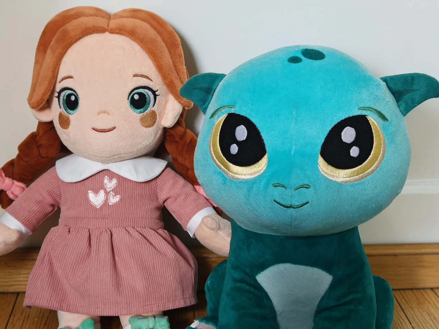 Lotti and Kobi together against a warm white wall, on a wooden floor